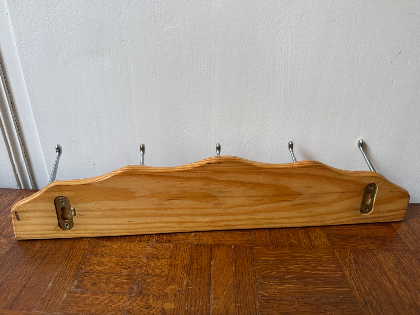 Wood and metal wall coat rack by Razzia, featuring multiple hooks and a modern, rustic design for home entryways.