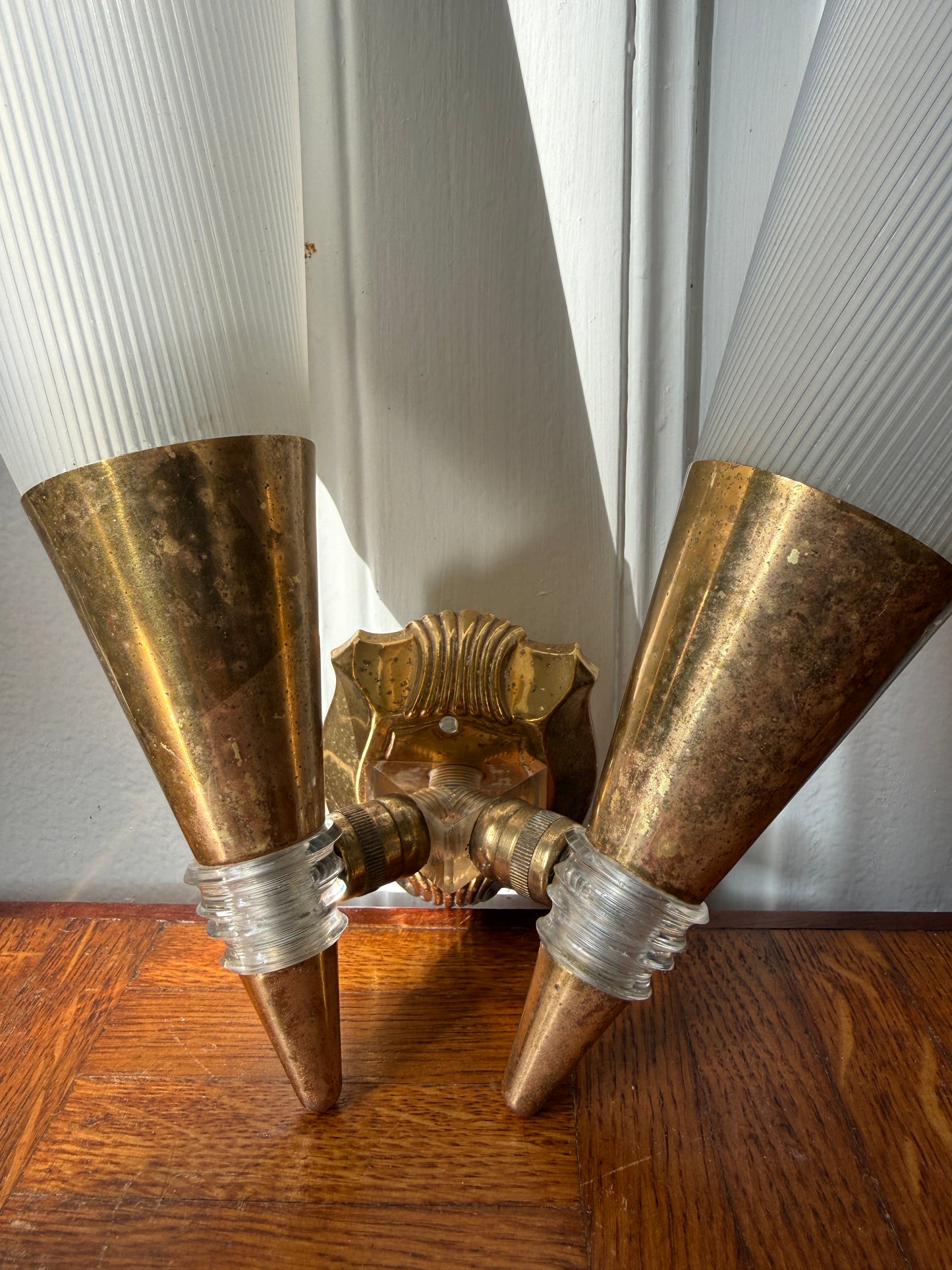 Razzia brass and plastic wall sconce with modern design, featuring sleek metallic and matte finish details.