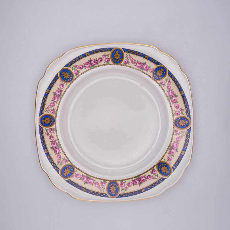 Small blue square plates by Razzia Days, featuring a classic German design, shown in a close-up of the patterned ceramic surface.