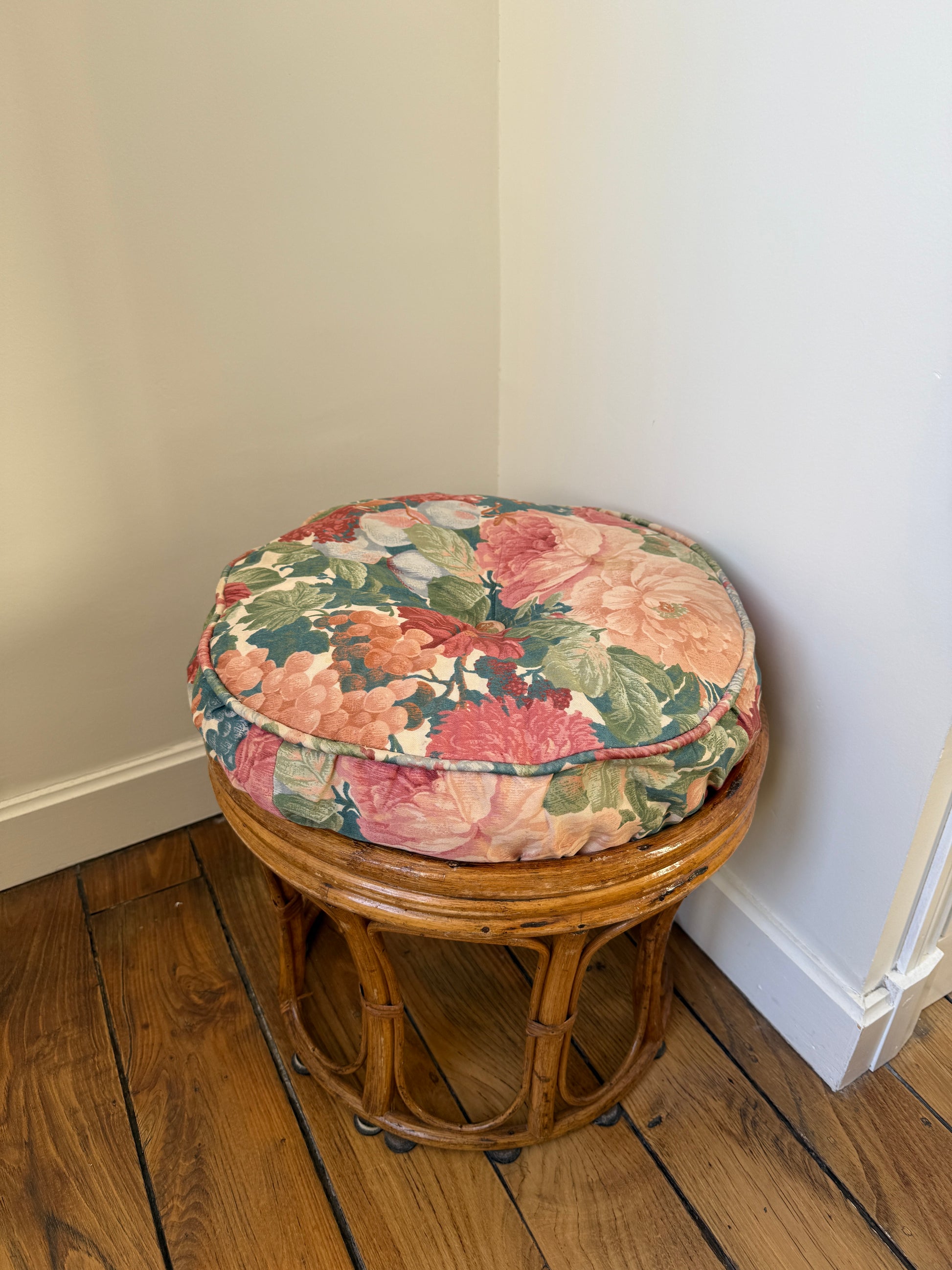 Vintage Razzia rattan stool with a fabric cushion, featuring a natural woven design and sturdy wooden legs.