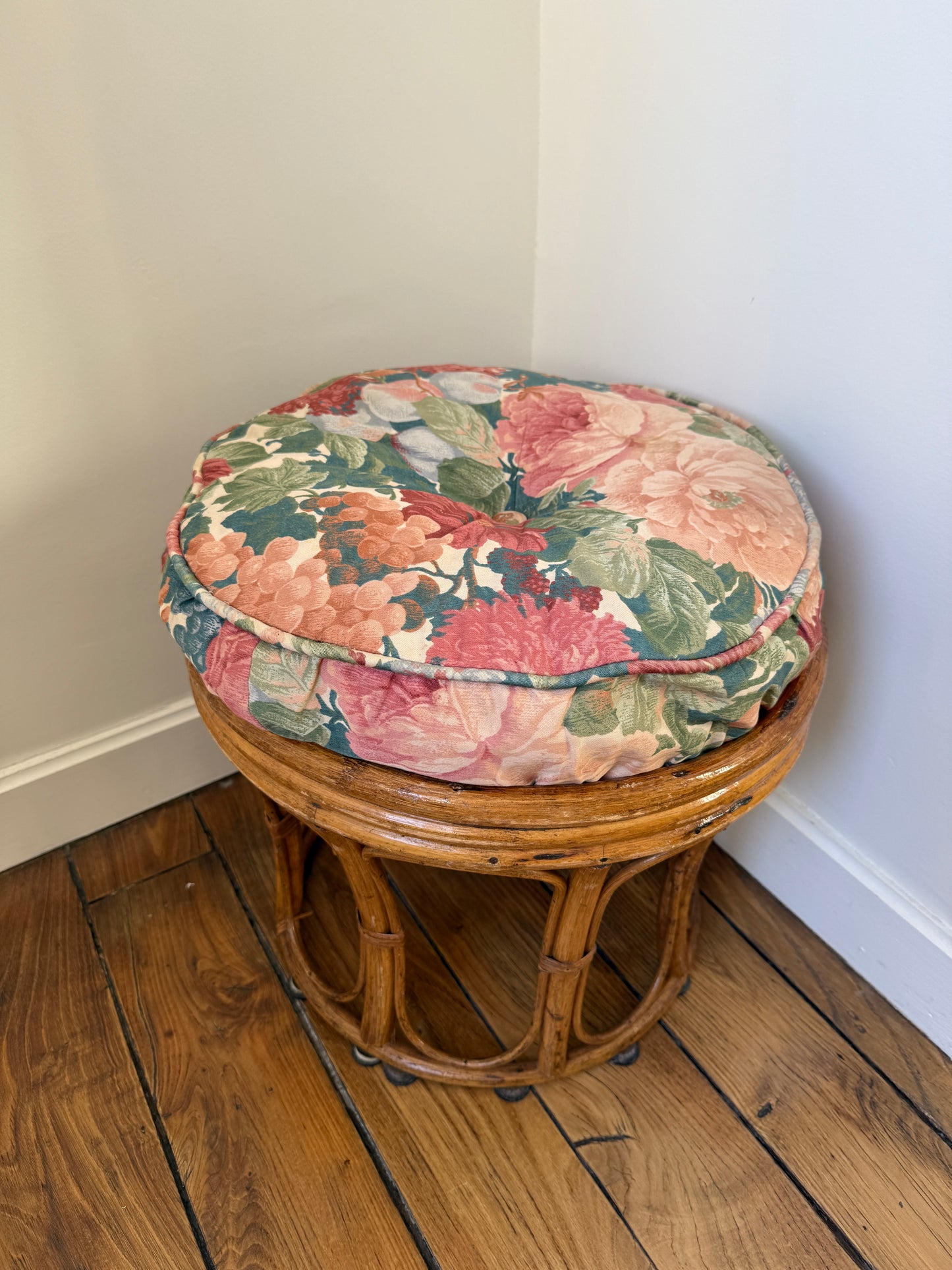 Vintage Razzia rattan stool with fabric cushion, showcasing a stylish and natural design with woven rattan legs and colorful fabric seat.