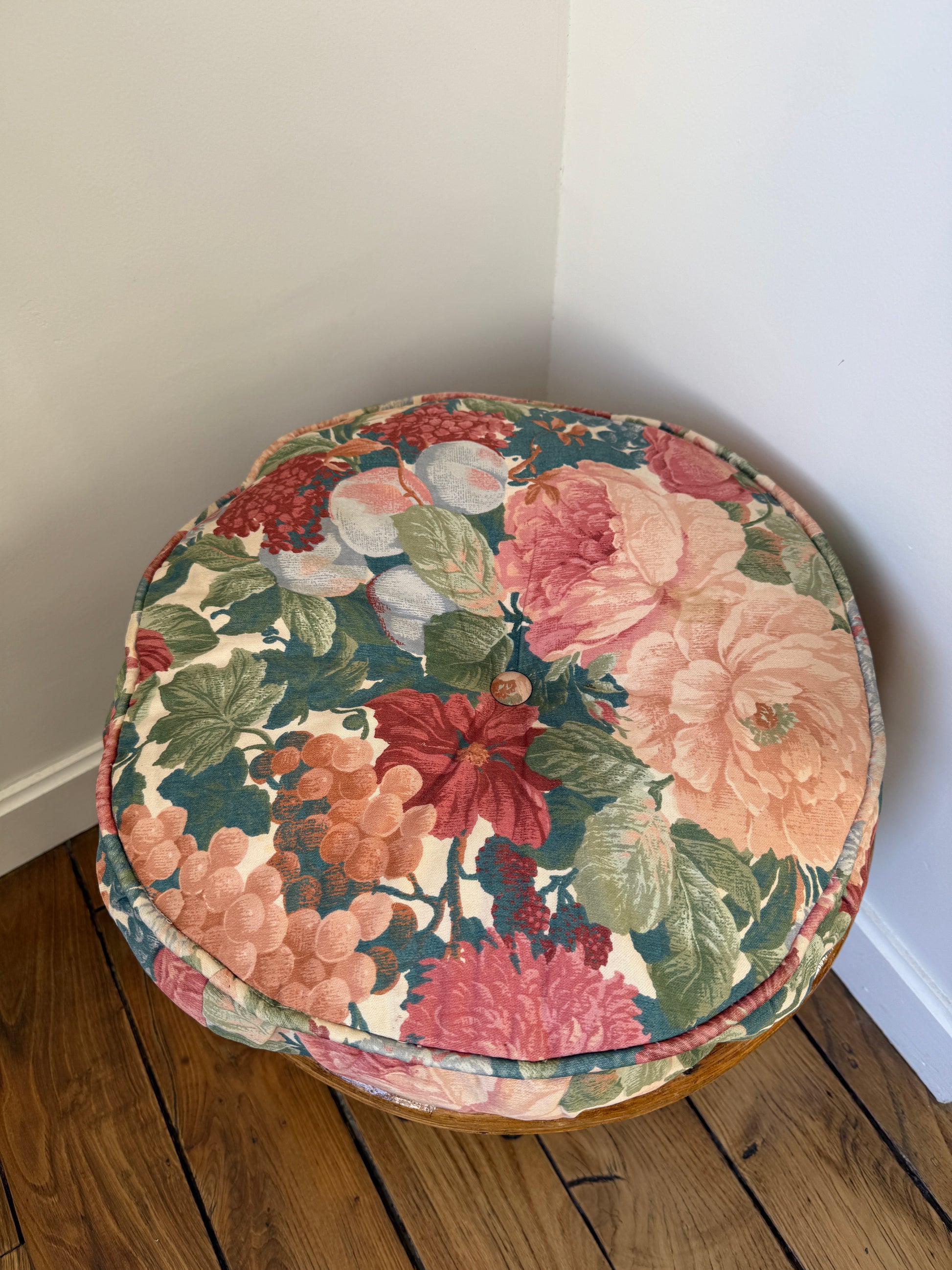 Vintage Razzia rattan stool with fabric cushion, showcasing woven rattan legs and a cozy fabric seat.