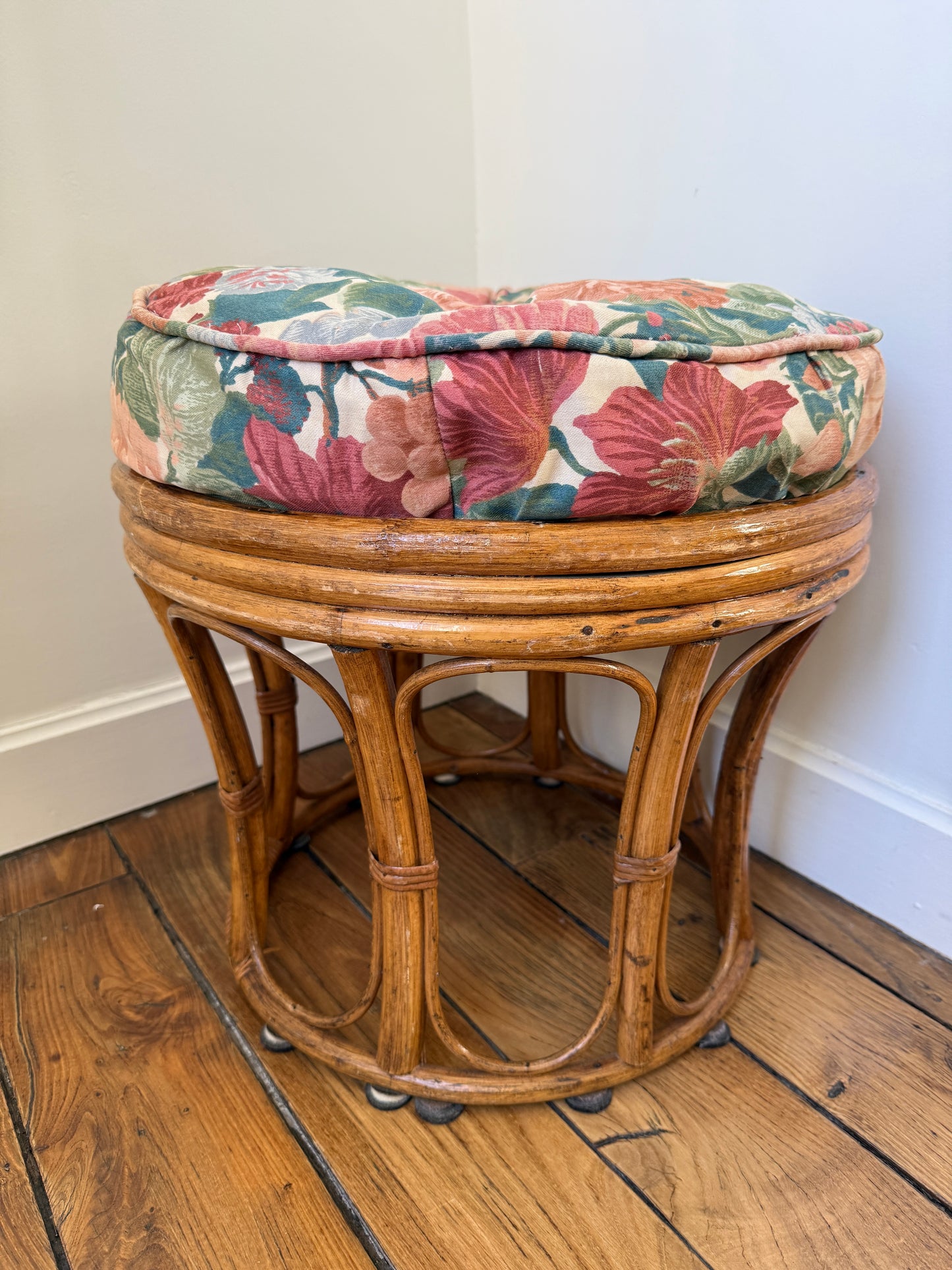 Vintage Razzia rattan stool with a cushioned fabric seat, showcasing woven rattan craftsmanship and classic design.
