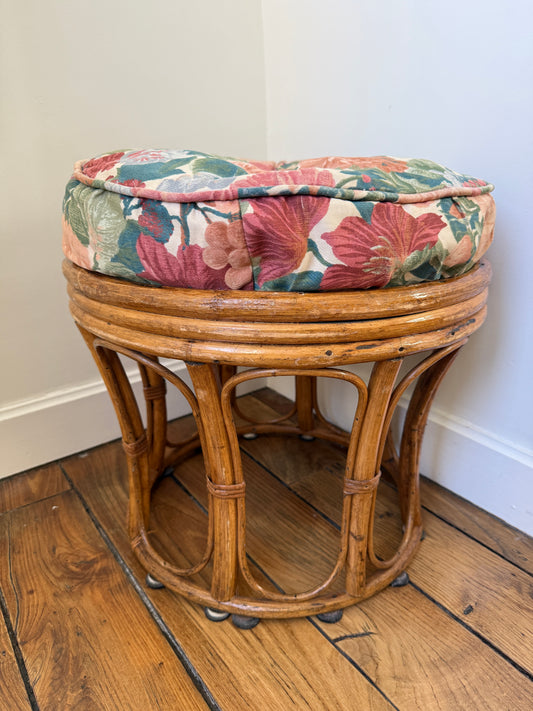 Vintage Razzia rattan stool with a cushioned fabric seat, showcasing woven rattan craftsmanship and classic design.