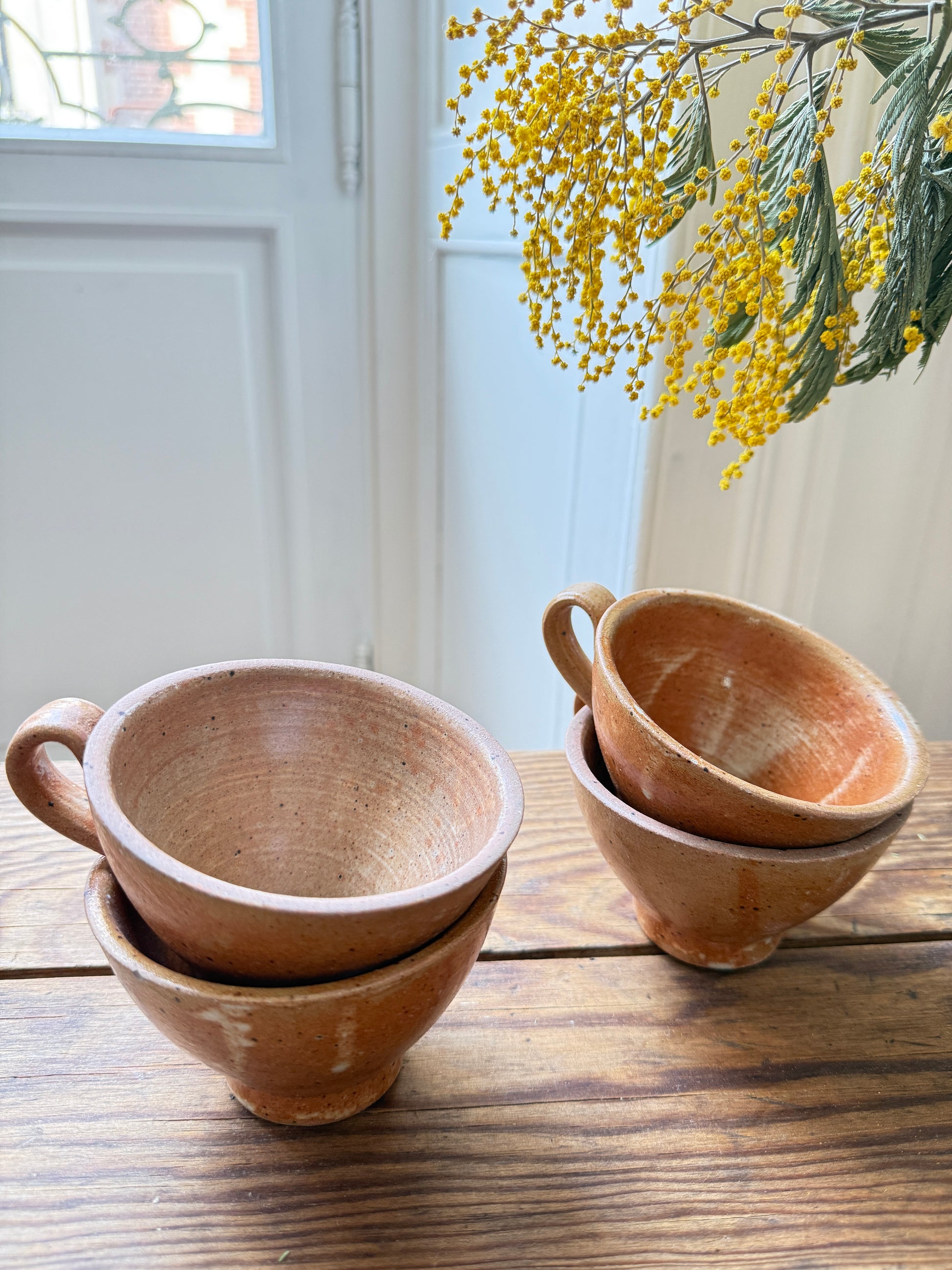 Set of four Razzia artisanal stoneware mugs with rustic, handcrafted design and natural glaze finish.