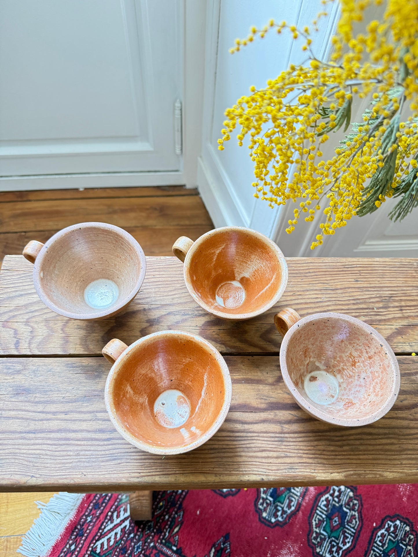Set of four artisanal stoneware coffee cups by Razzia, showcasing rustic design and textured glazed surfaces.