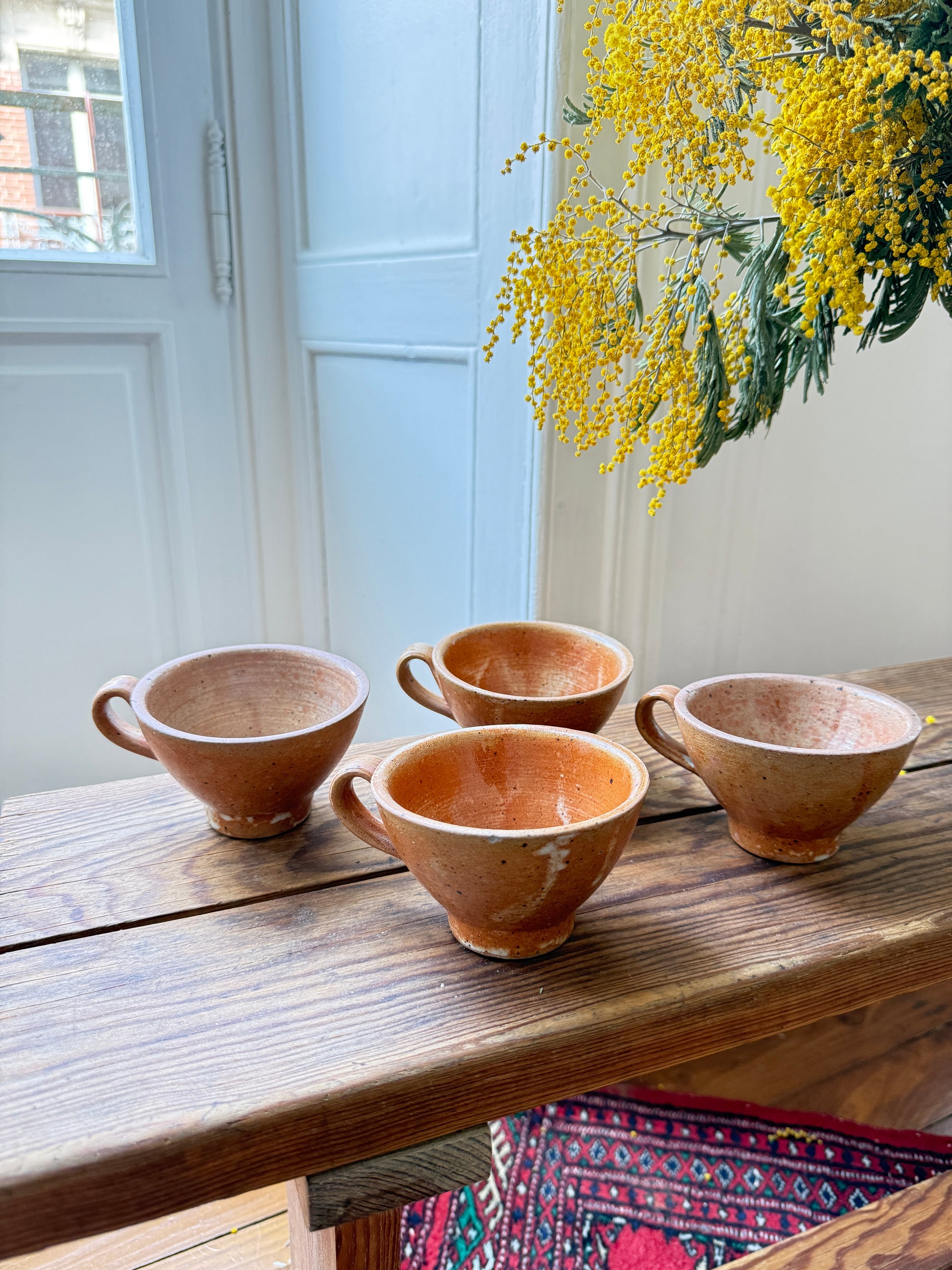 Set of four Razzia artisanal stoneware mugs with rustic, handcrafted design, featuring natural textures and earthy tones.