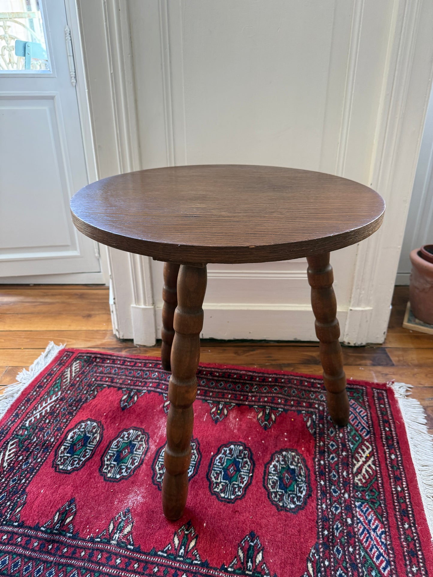 Wooden tripod side table with brutalist design by Razzia, featuring a sturdy, minimalist wooden frame and a round tabletop.