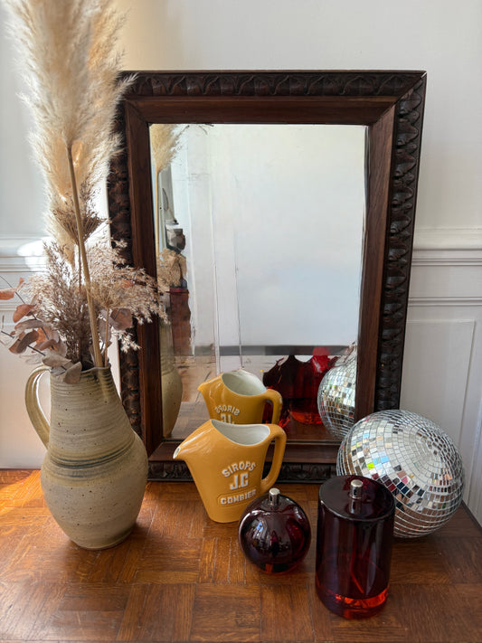 Vintage carved wooden mirror with ornate details, showcasing timeless charm and intricate craftsmanship by Razzia.