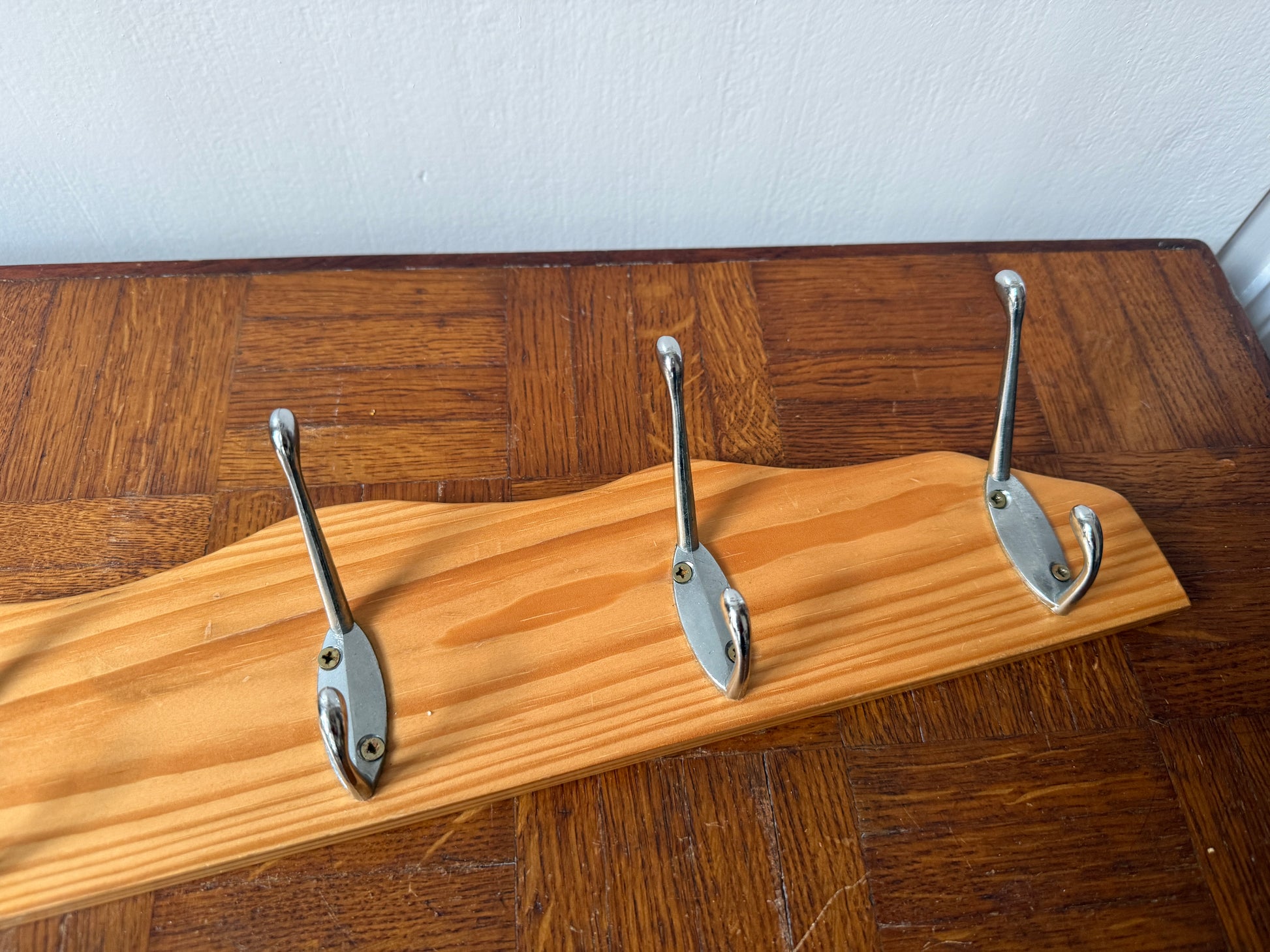 Wood and metal wall coat rack by Razzia featuring hooks and a modern design for organized entryway storage.