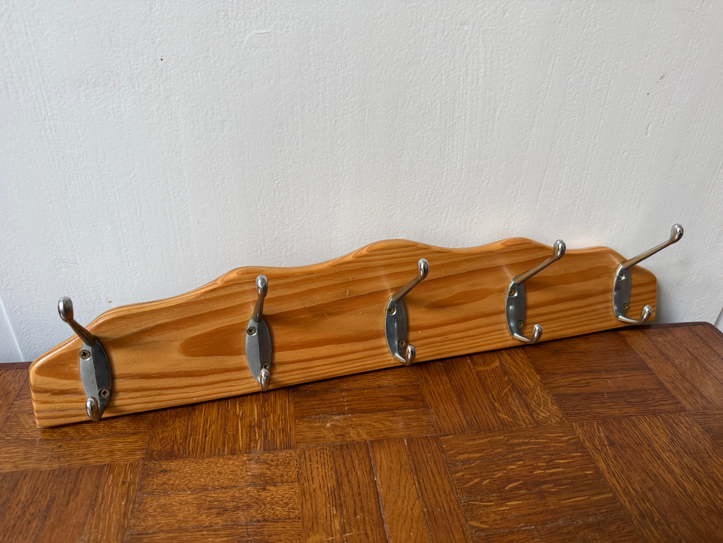 Wood and metal wall coat rack by Razzia, featuring hooks and a sleek design for hanging coats and accessories.