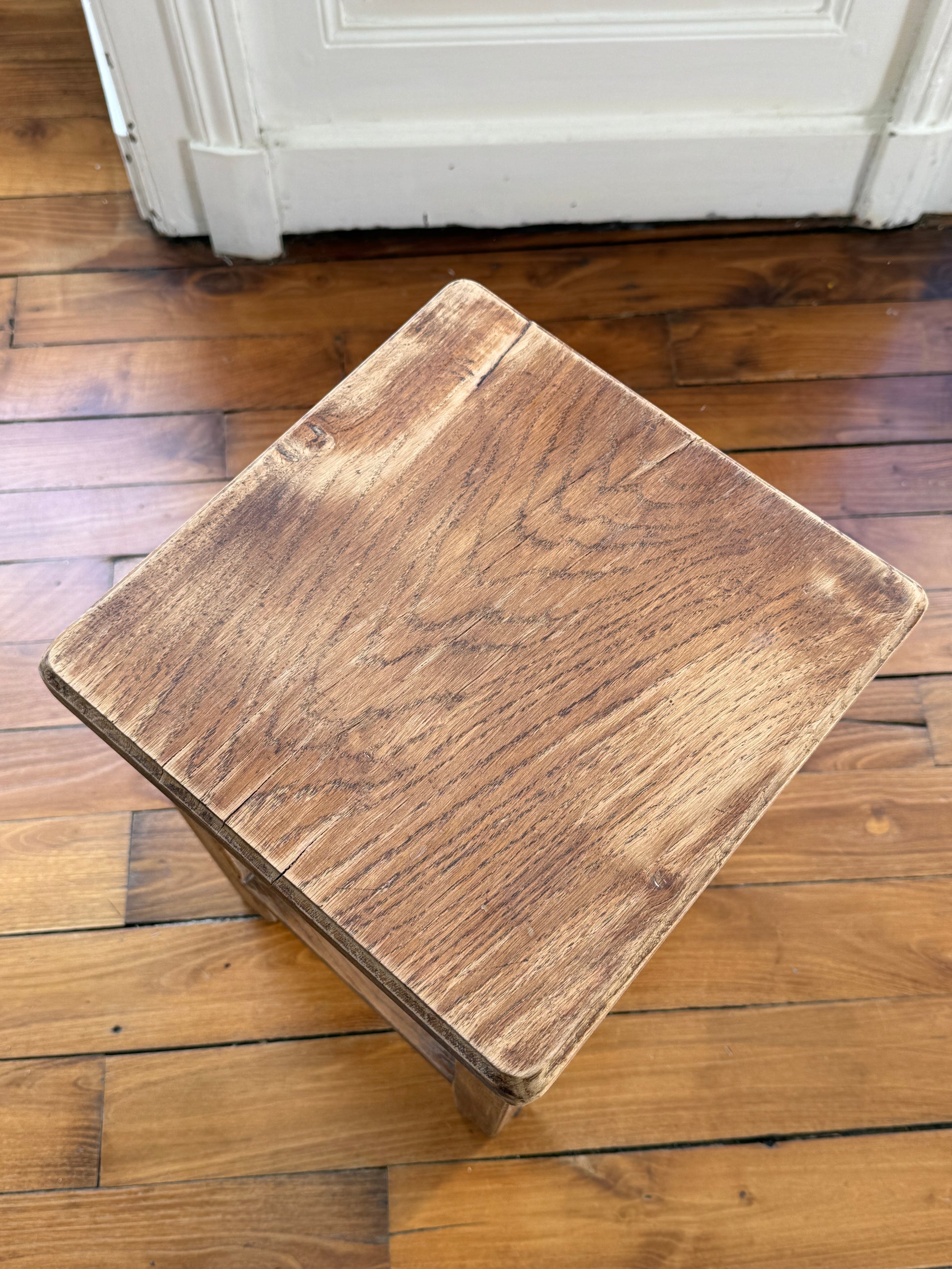 Brutalist wooden stool with aged, distressed finish by Razzia, featuring a sturdy, rustic design perfect for modern interior decor.