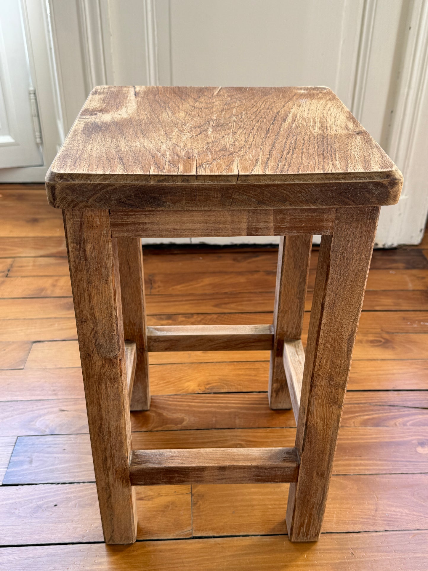 Razzia brutalist wooden stool with distressed, aged finish, showcasing a rustic, minimalist design and natural wood texture.