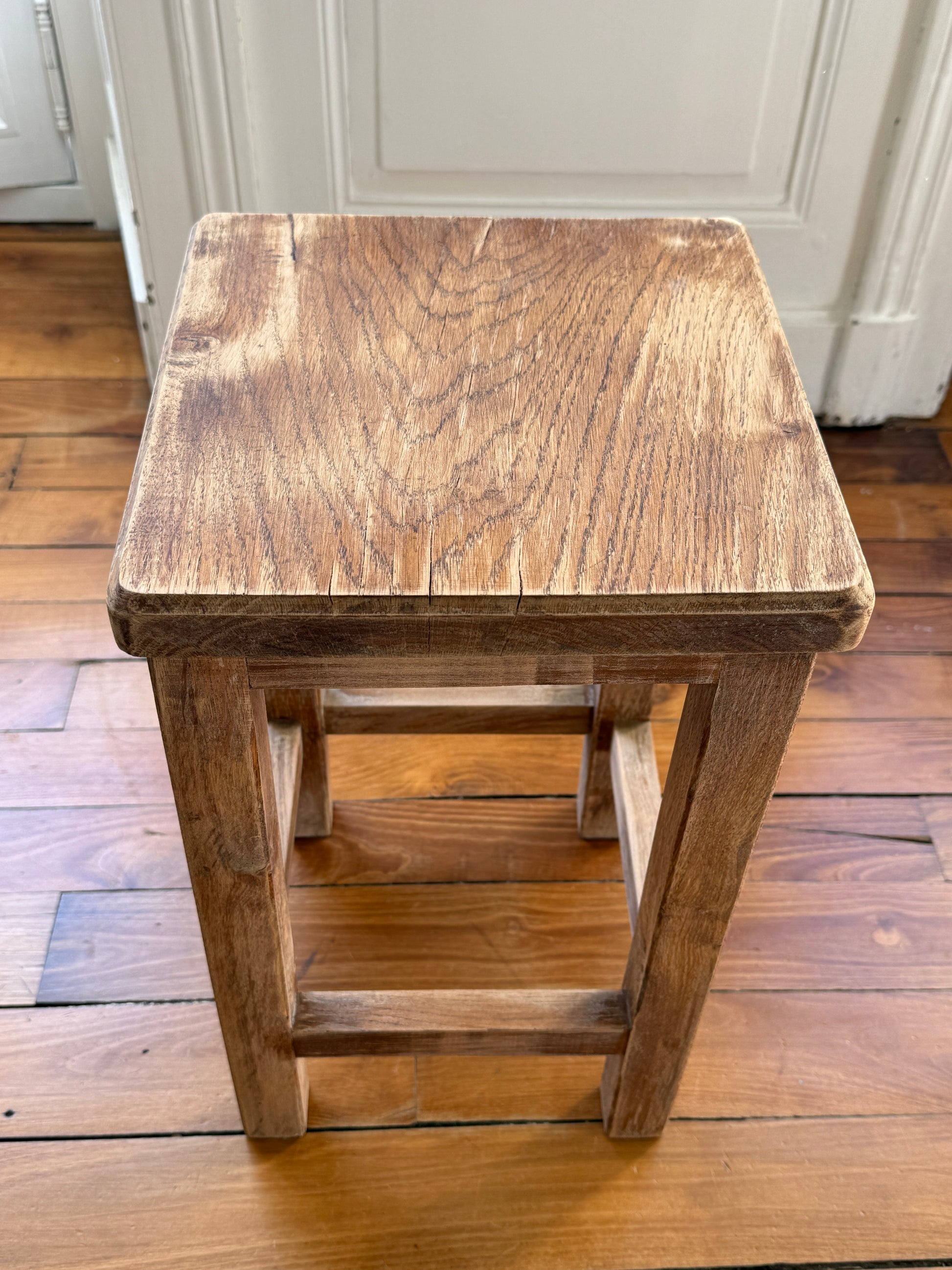 Wooden brutalist stool by Razzia with distressed, aged finish and natural wood texture, showcasing a sturdy, minimalist design.