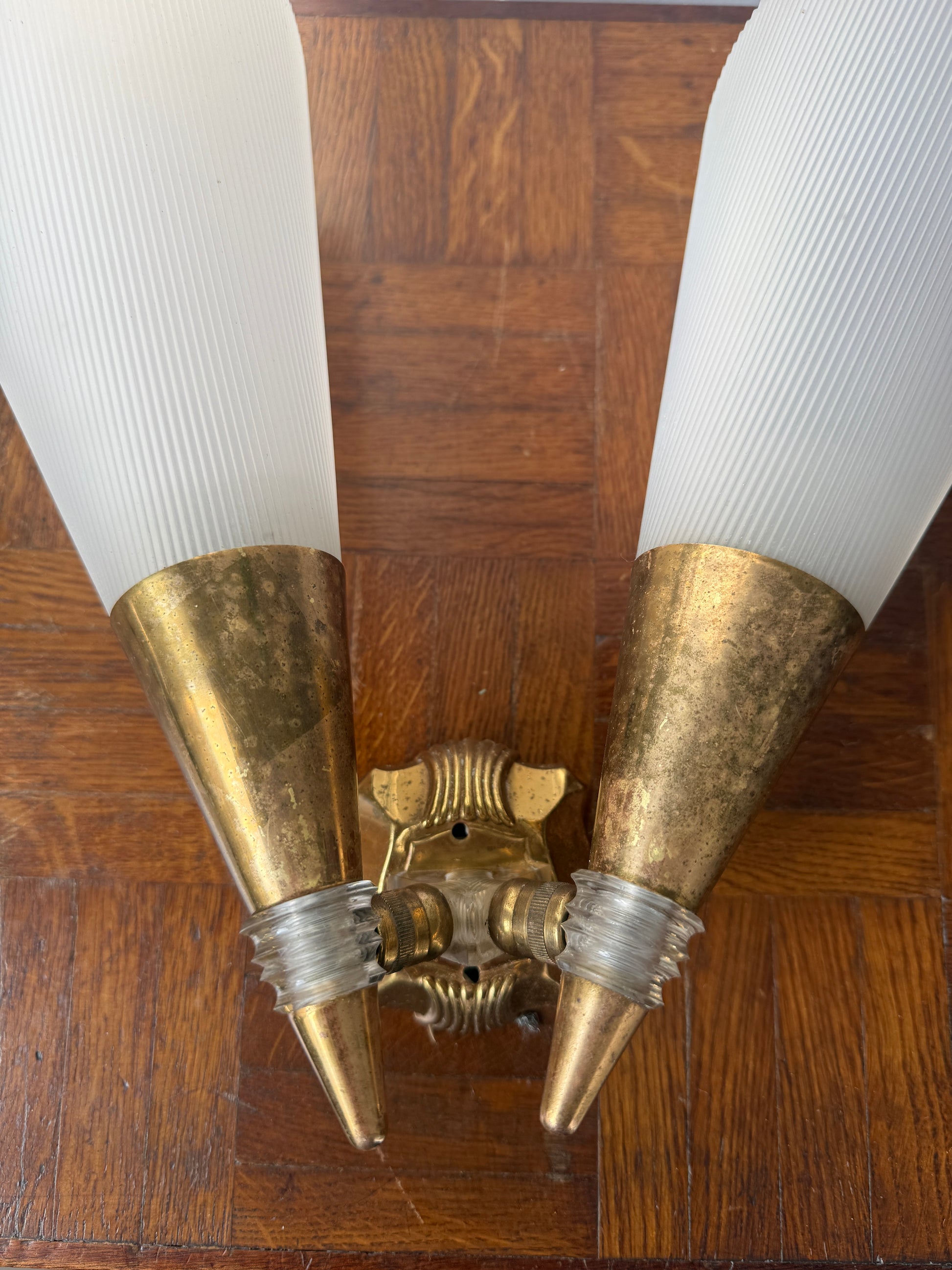 Brass and plastic wall sconce by Razzia, featuring a sleek modern design with a white shade and brass accents.
