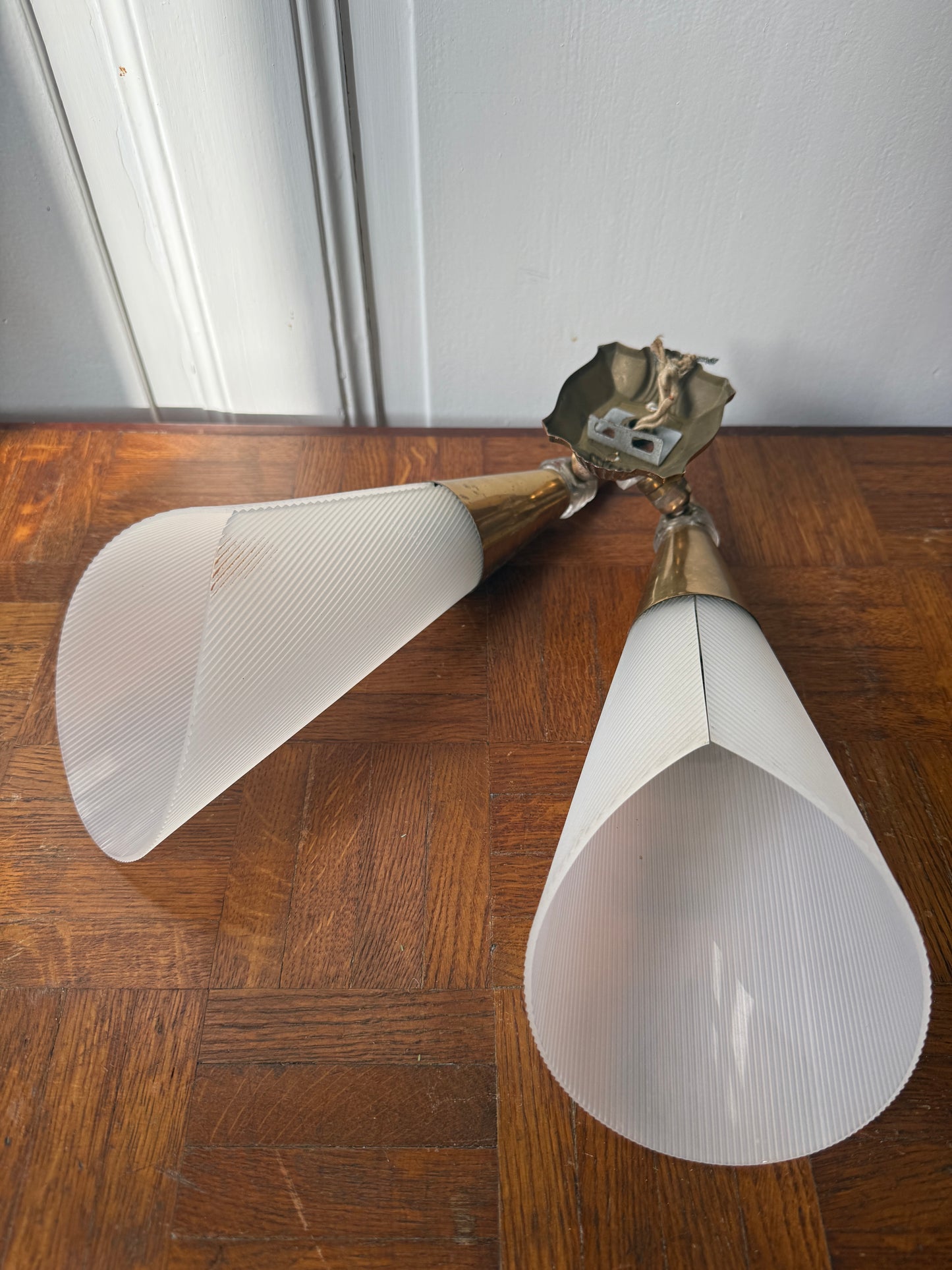 Decorative wall applique with brass and plastic components, featuring a sleek, modern design for stylish interior lighting.