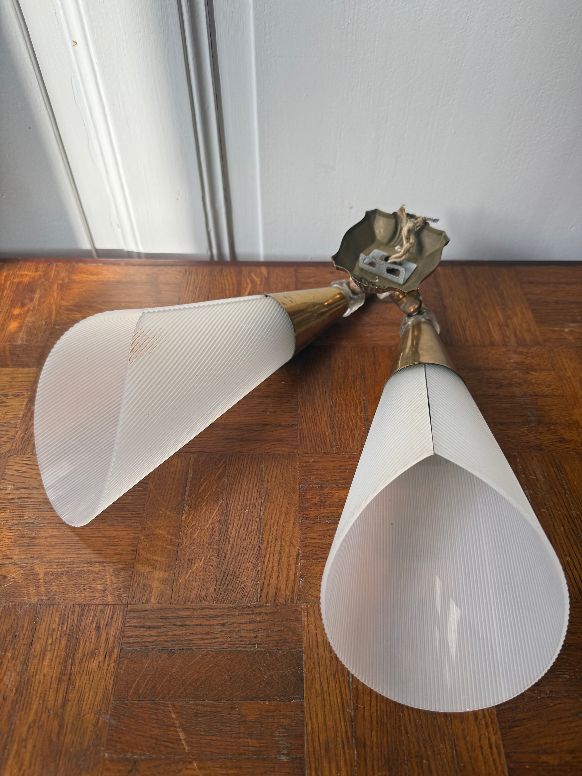 Decorative wall applique with brass and plastic components, featuring a sleek, modern design for stylish interior lighting.