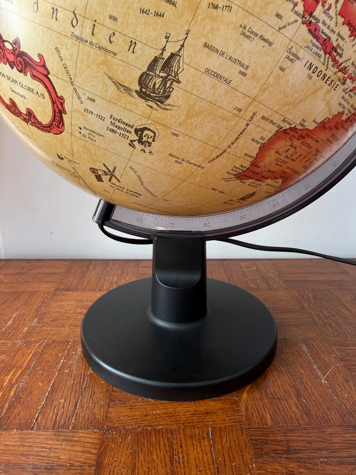 Globe lumineux Razzia Scanglobe au design vintage danois, mettant en valeur une carte géographique classique et un éclairage intégré.