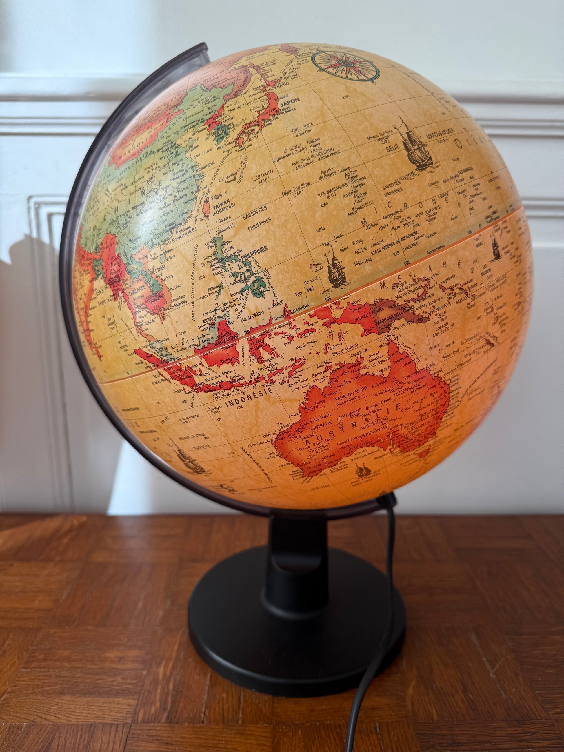 Globe lumineux Razzia, design vintage danois, avec éclairage intégré, posé sur une table en bois.