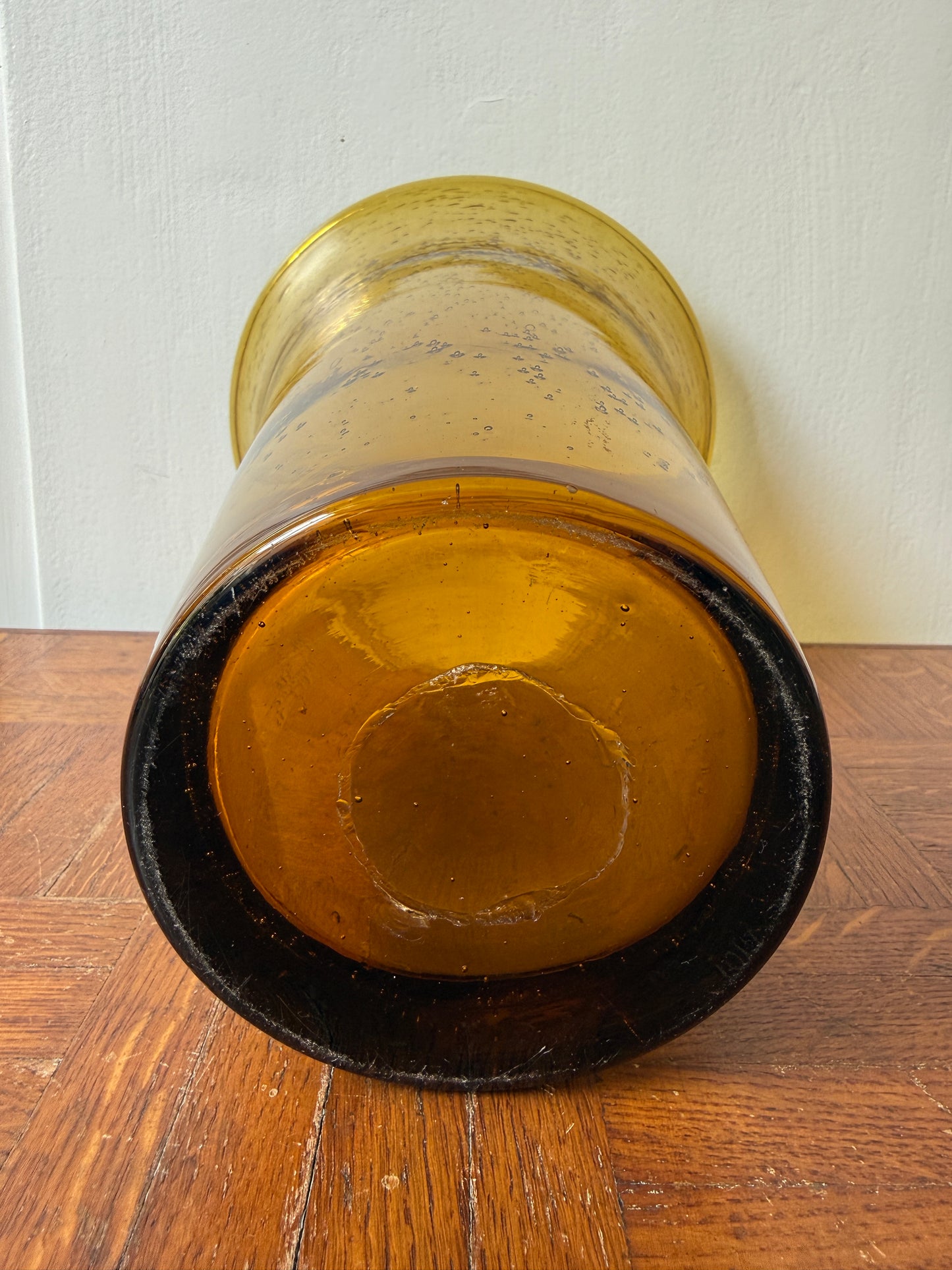 Vase Biot en verre soufflé Razzia avec teinte ambrée, élégant et translucide, posé sur une surface neutre.