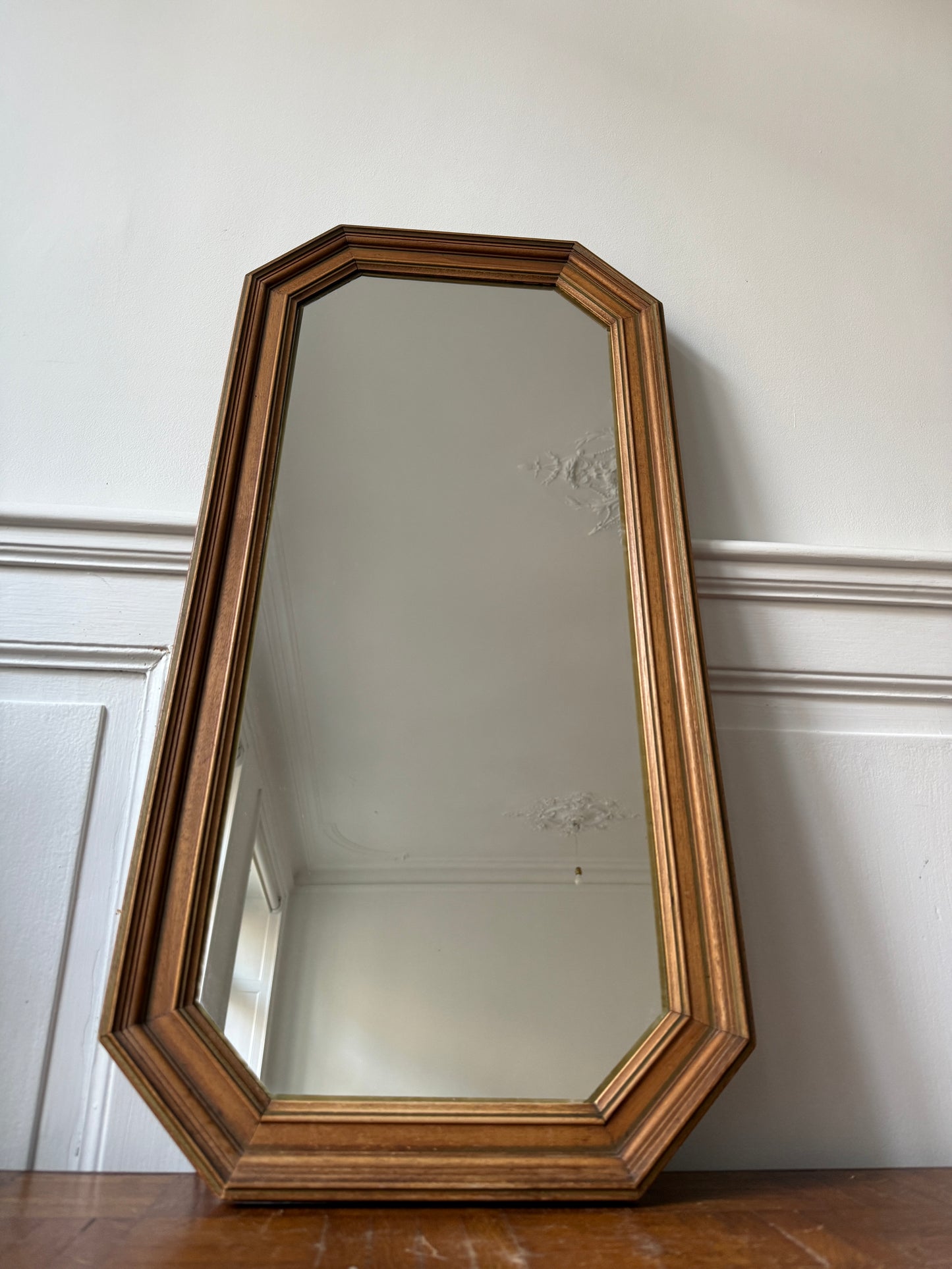 Miroir octogonal nervuré en bois doré de la marque Razzia, avec cadre en bois doré orné de détails nervurés.