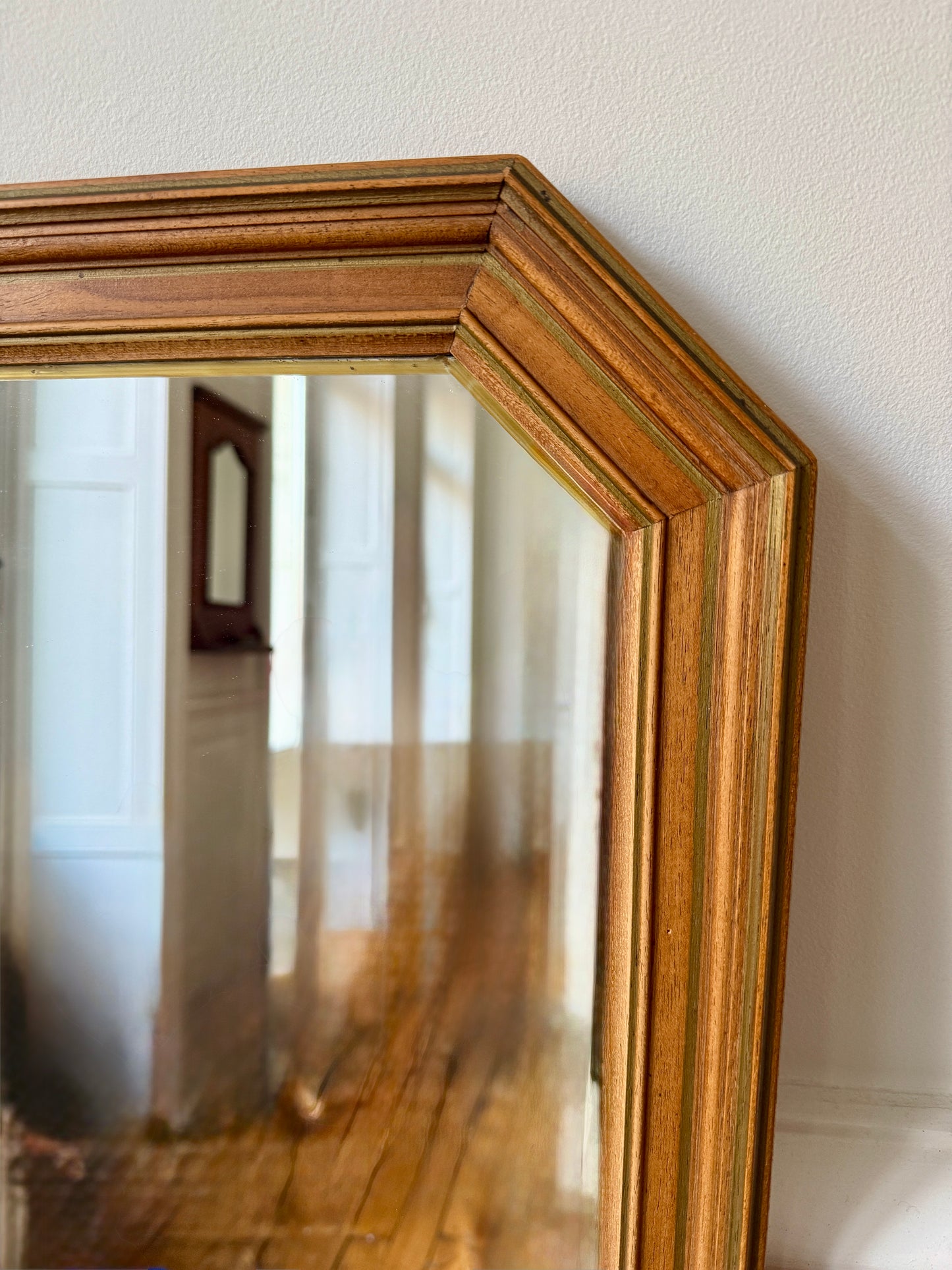 Miroir octogonal nervuré en bois doré de la marque Razzia, avec cadre élégant et détails texturés en bois doré.