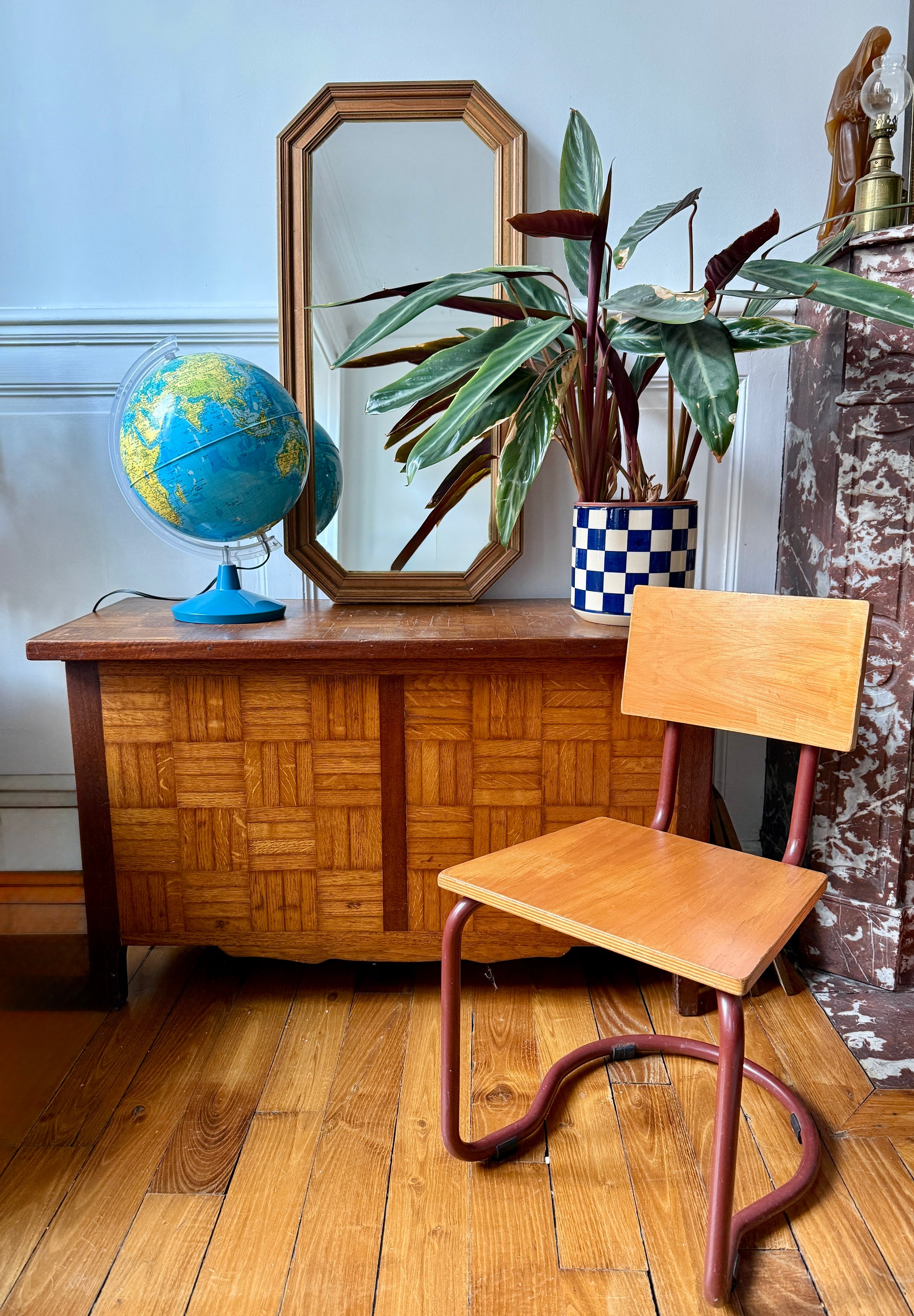 Miroir octogonal nervuré en bois doré Razzia, avec cadre élégant et détails texturés, posé contre un mur.