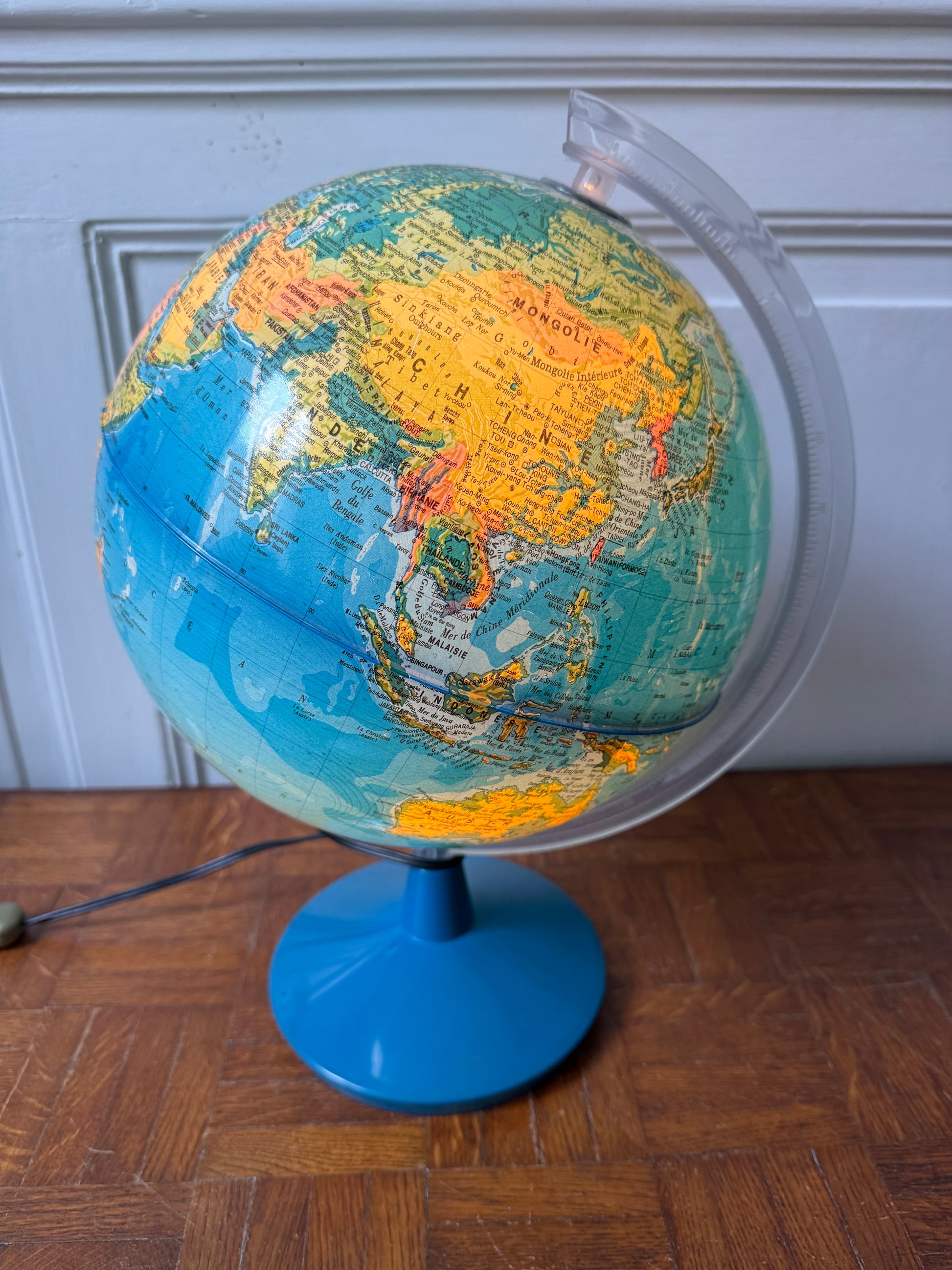 Globe terrestre lumineux Razzia avec illumination bleue, détails géographiques visibles, support en métal noir.