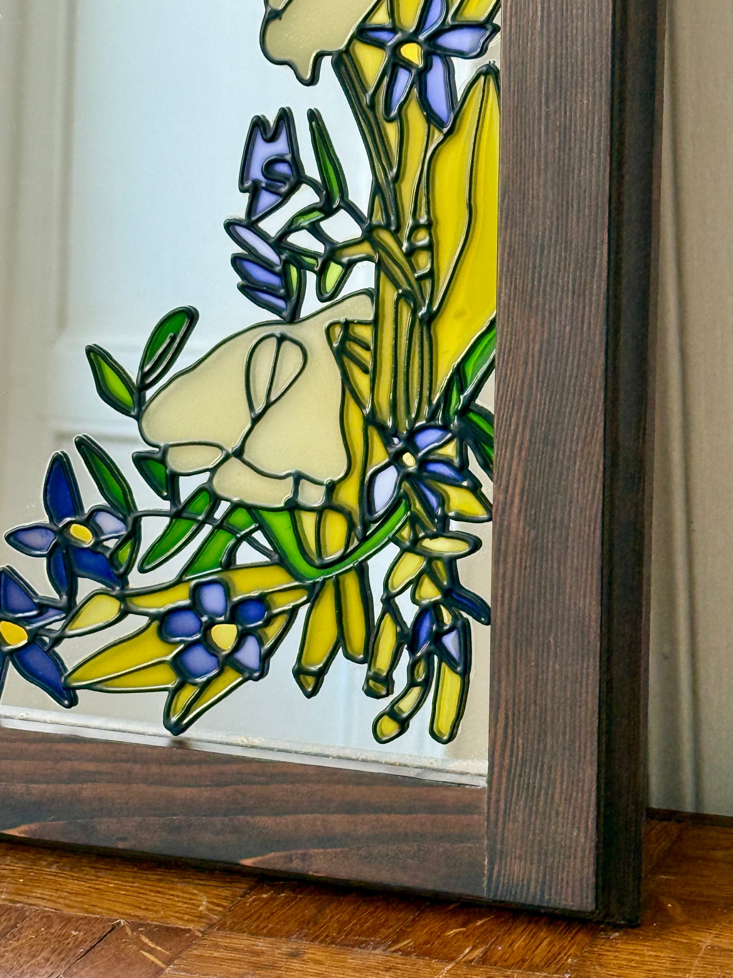 Miroir Tiffany et Art Déco de style Razzia avec cadre élégant et motifs géométriques, reflet dans le miroir.