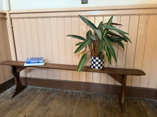 Ancien banc en bois robuste de la marque Razzia, avec une finition patinée et un design vintage, posé sur un sol en pierre.