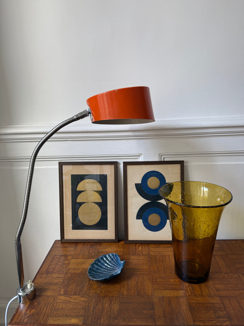 Lampe d’atelier orange à étau Razzia des années 70, avec base en métal et bras articulé, éclairage industriel vintage.