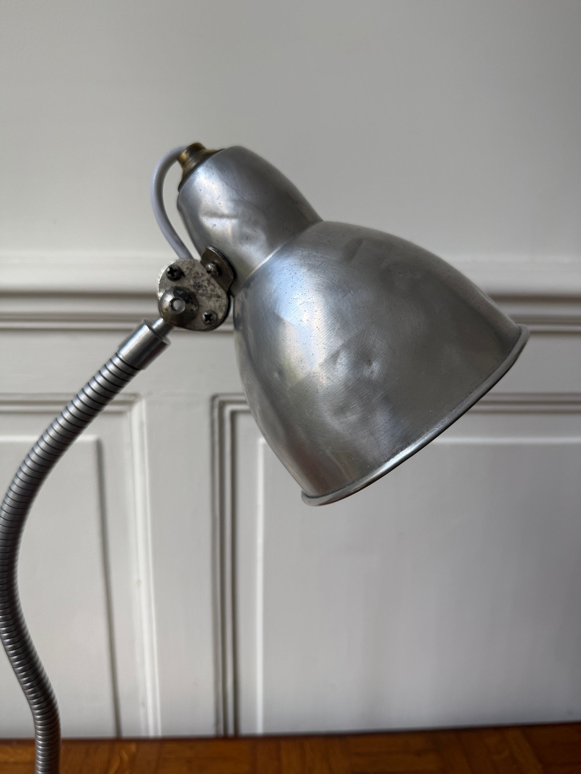 Lampe de bureau industrielle articulée Razzia des années 50, avec bras réglable en métal noir et abat-jour vintage.