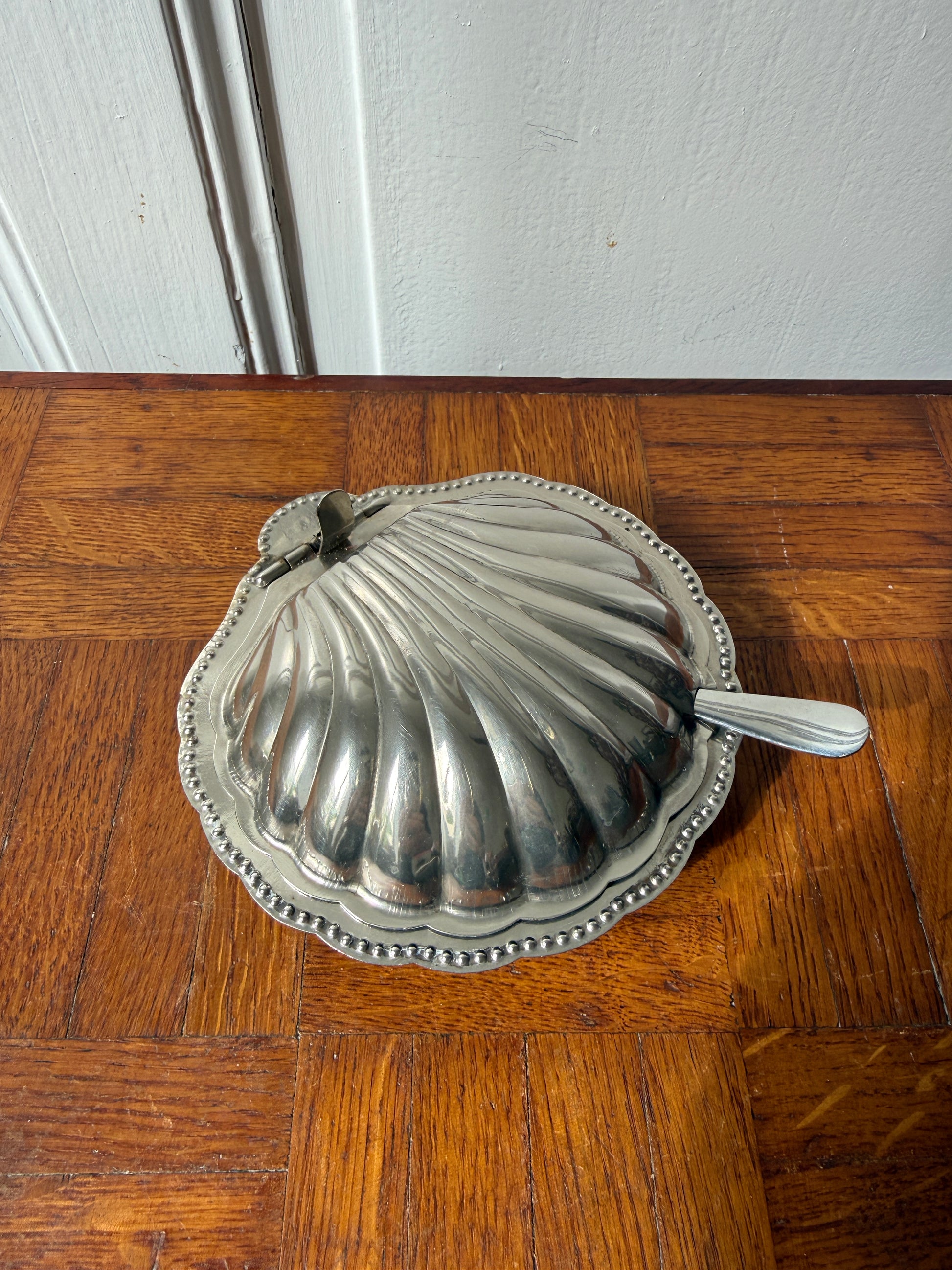 Beurrier coquillage en inox Razzia, élégant récipient pour beurre avec motif coquillage, finition brillante, sur fond neutre.