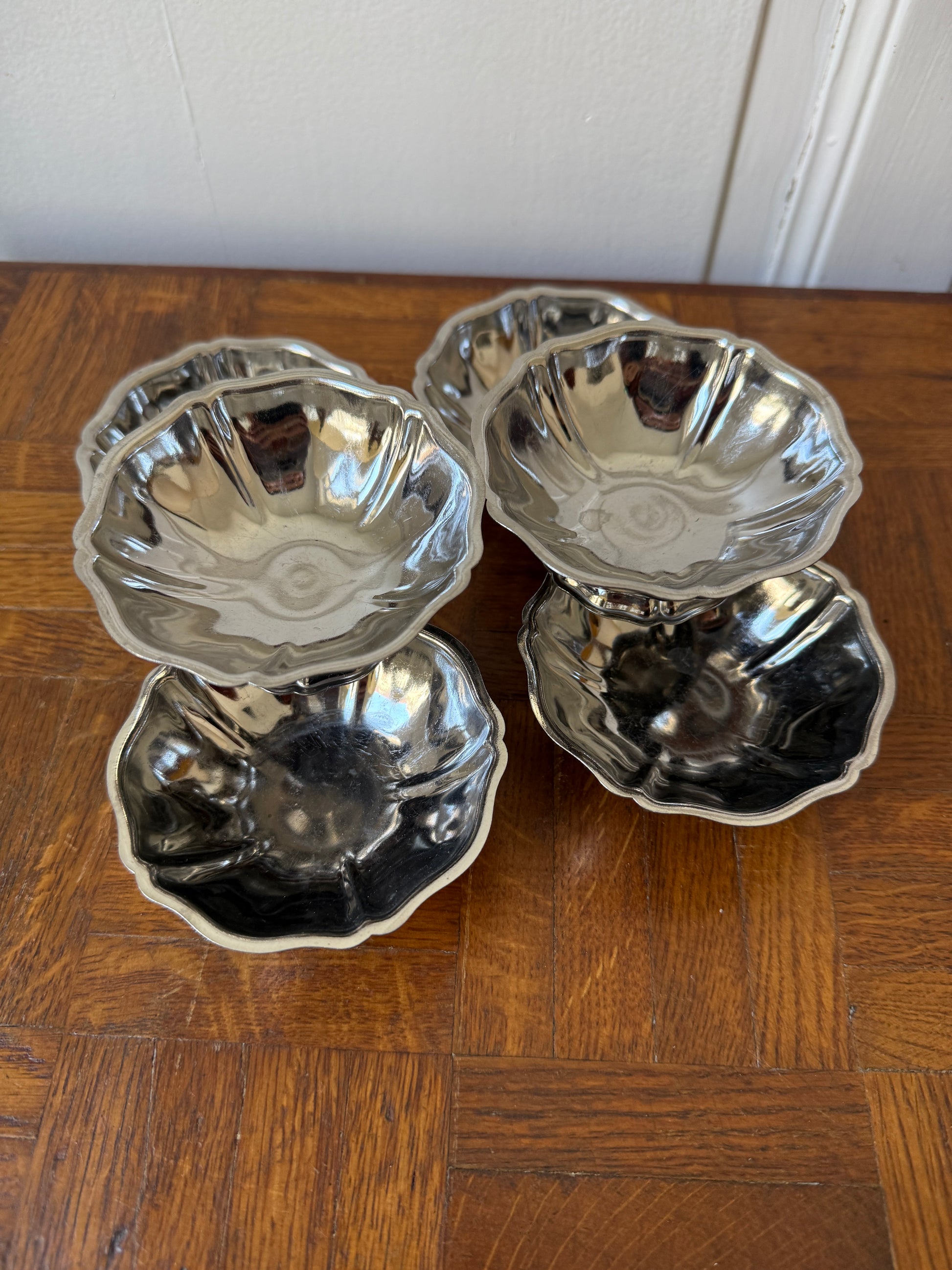 Six coupes en inox Razzia, empilées, avec finition brillante, parfaites pour servir boissons dans une cuisine moderne.