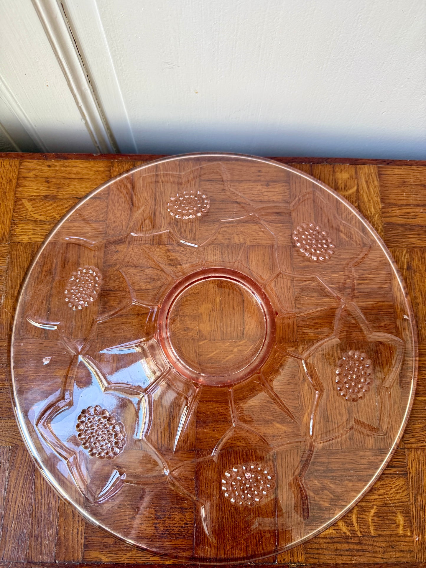 Plat en rosaline Razzia avec motifs floraux, design élégant et coloré pour la décoration ou la présentation.