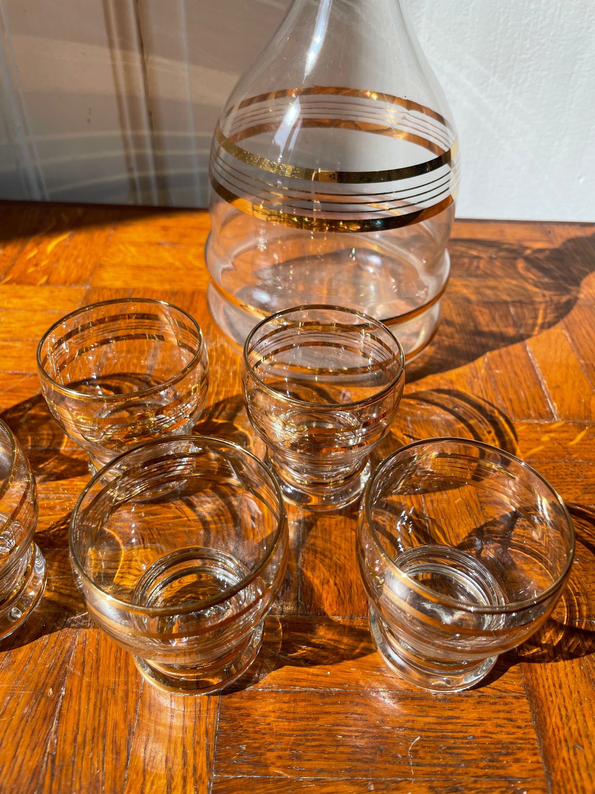 Vintage Razzia Days carafe and liqueur glasses set, clear glass with elegant design, displayed on a wooden surface.