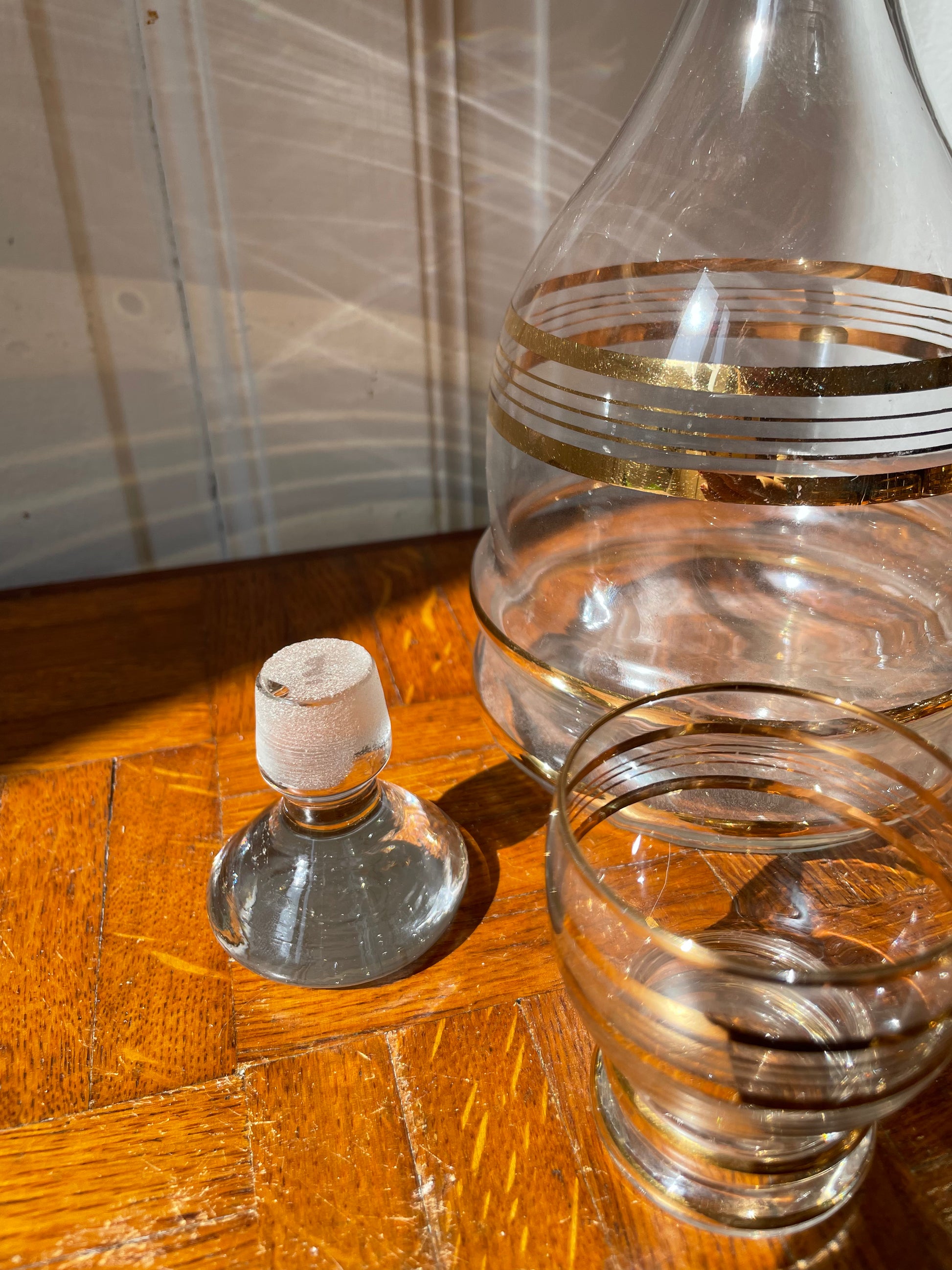Vintage Razzia Days carafe and liqueur glasses set, clear glass with elegant design, displayed on a wooden surface.