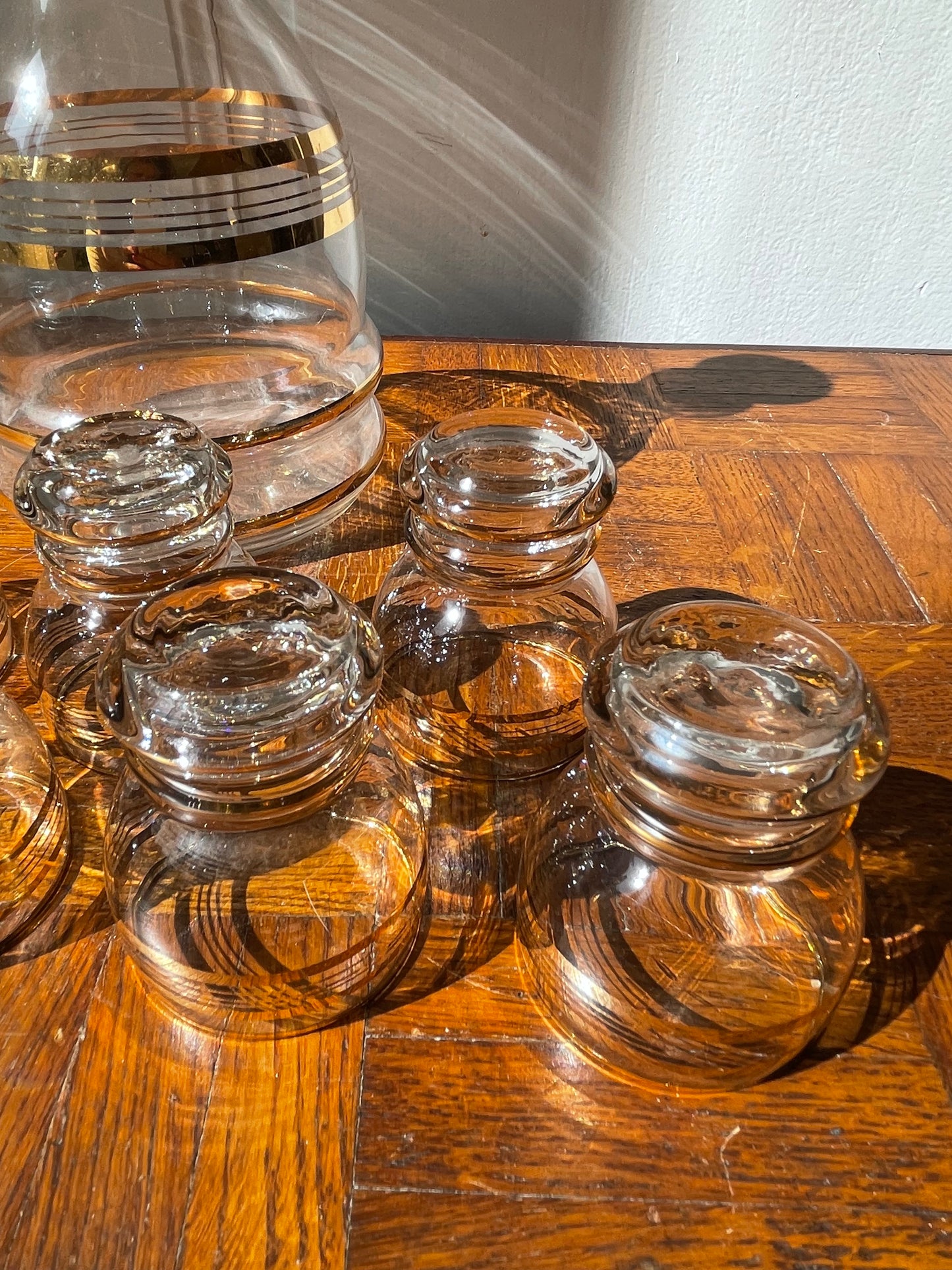 Vintage Razzia Days carafe and liqueur glasses set with clear glass and elegant design, displayed on a wooden surface.