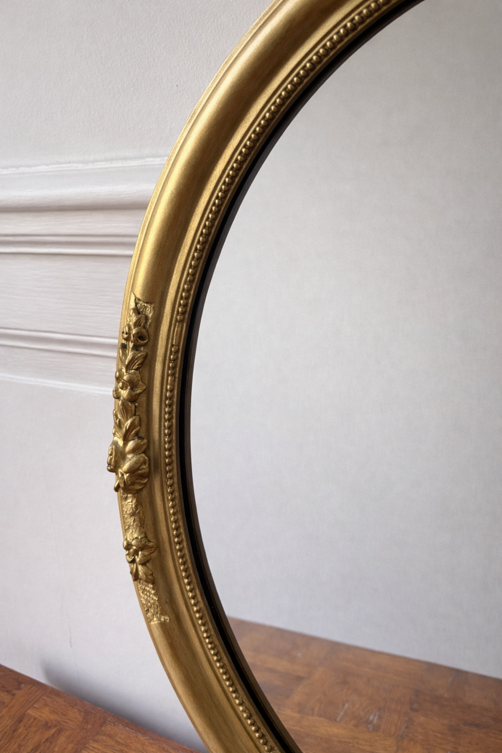 Miroir ovale doré style victorien avec cadre orné de détails floraux, design élégant et sophistiqué, par Razzia.